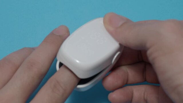 Oximeter usage. Finger pulse oximeter used to measure pulse rate and oxygen levels. Home self care during Covid 19 pandemic. healthcare monitoring concept. using portable fingertip pulse oximeter. 4k