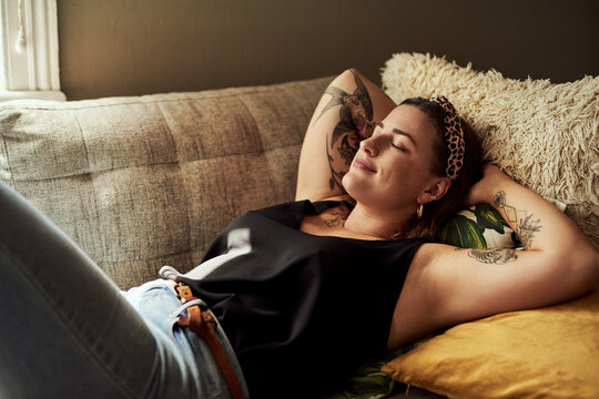 This is why weekends were invented. Shot of a young woman relaxing on the sofa at home.