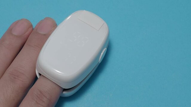 Oximeter usage. Finger pulse oximeter used to measure pulse rate and oxygen levels. Home self care during Covid 19 pandemic. healthcare monitoring concept. using portable fingertip pulse oximeter. 4k