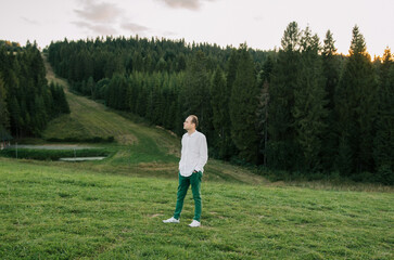 Portrait of a man against the backdrop of the green mountains of the Carpathians