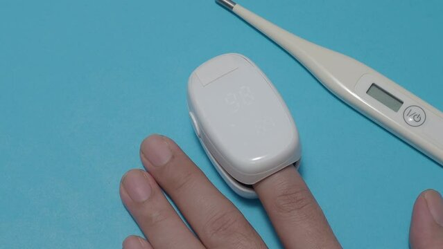 Oximeter usage. Finger pulse oximeter used to measure pulse rate and oxygen levels. Home self care during Covid 19 pandemic. healthcare monitoring concept. using portable fingertip pulse oximeter. 4k