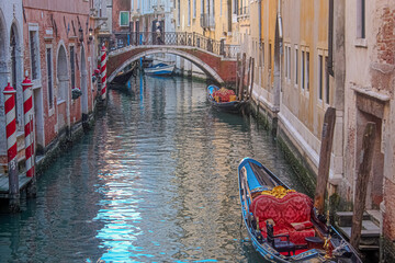 gondolas in a canal with a bridge in Venice