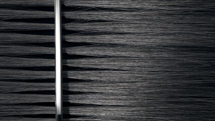 Vertical shot of Silver comb combing black hair | Hair loss treatment concept