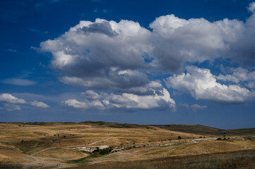 Plain and steppe with dry grass under a blue sky against background of mountains in Crimea