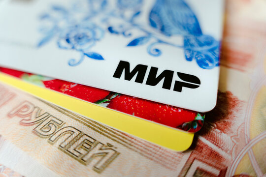 Mir Payment Card On Background Of Paper Rubles. Close Up. Russia's New Payment System