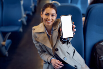 Close up of train passenger with empty white screen on cell phone.