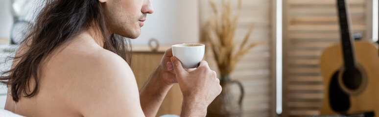 cropped view of shirtless man with long hair holding cup of coffee, banner.