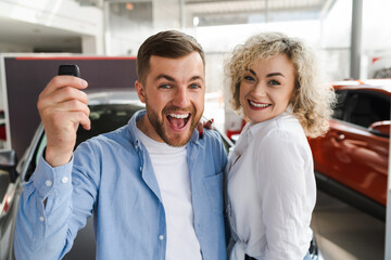 Happy couple in a car dealership