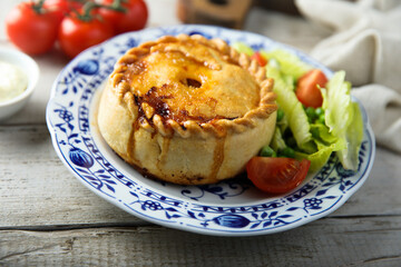 Traditional British meat pie with fresh salad