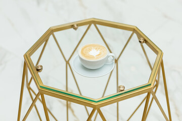 A cup of coffee, a glass table. Geometry. Modern. Interior.