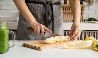 High angle view of female hands cutting banana