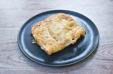 fried mashed pork with tomato and onion stuffed in Thai egg omelets on dish