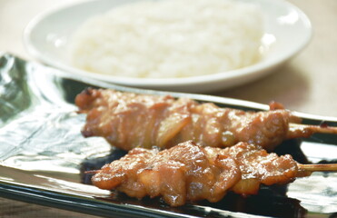 grilled pork in wooden stick eat with sticky rice on dish