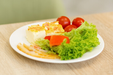 Lettuce leaves, tomatoes, omelet. Fresh vegetables on a plate. Proper nutrition, a healthy need for life.