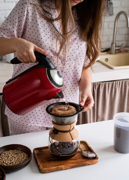 young woman in lovely pajamas making coffee at home kitchen