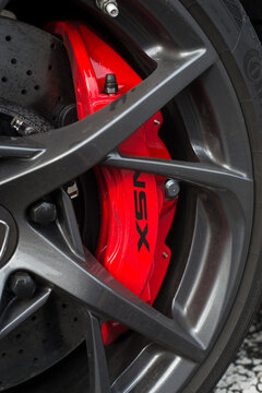 Lutterbach - France - 3 April 2022 - Closeup of red brake on grey wheel  of Honda NSX parked in the street