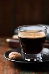 Coffee in glass cup on dark wooden background. Close up.