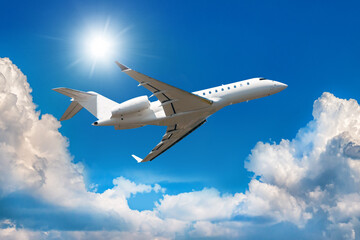 Naklejka na ściany i meble White modern luxury private jet flies in the air above the clouds