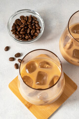 Irish cream liqueur in a glass with ice cubes and coffee beans, top view