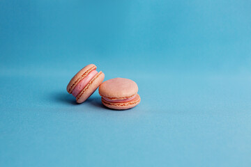 The middle plan of a colorful cake with almond cookies or pasta, isolated in vintage pastel colors on a blue background with a space to copy. Small French pastries.