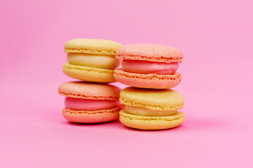 Yellow macaroons on a pink background.