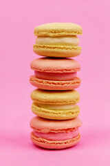 Yellow macaroons on a pink background.
