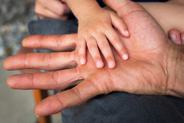 Photograph of a little girl holding on to his father's hand