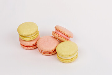 A lot of macaroons on a  white background with a place for pastel-colored lettering. Stylish layout. Delicious cakes. Aesthetics.