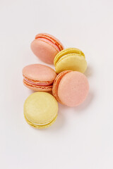 a lot of macaroons on a plain white background with a place for pastel-colored lettering. Stylish layout. Delicious cakes. Aesthetics.