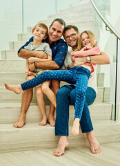 This home is filled with love. Full length portrait of an affectionate family of four on the stairs...