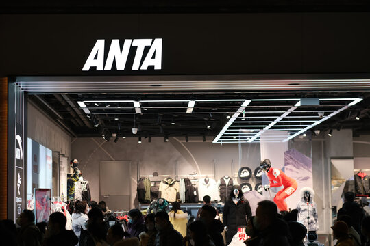 Shanghai,China-Jan.1st 2022: facade of ANTA Sports store and many pedestrians at night. Chinese sports equipment multinational corporation