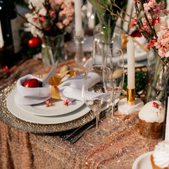 Festive Easter table setting. Funny Easter bunny made of egg and linen napkin on plate. Gray background.