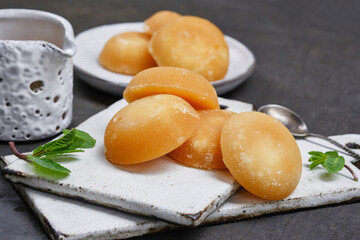 Several palm sugar cakes made from palm tree sap with mint on a white boards. Shallow depth of field