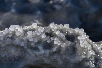Round salt crystals of the Dead Sea closeup in the rays of the sun. Israel