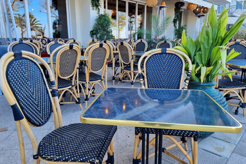 Wooden Chairs and tables in a Row in Empty Outdoor Restaurant.