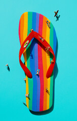 miniature men on a rainbow-patterned flip-flop