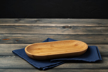 Wooden board with kitchen napkin on dark wooden table