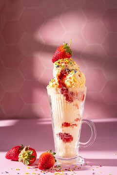 Vanilla ice cream milkshake garnished with fresh strawberry and colourful sprinkles