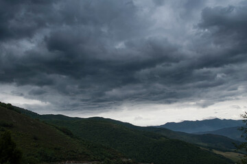 Cloudy sky with rain clouds above a mountain landscape