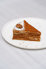 Piece of honey cake on a white plate