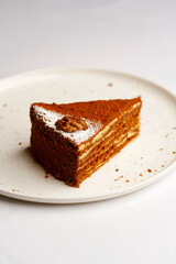 Piece of honey cake on a white plate