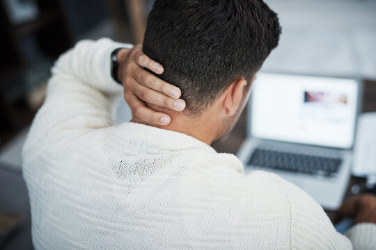 The More Stress, The Less Closer To Success. Rearview Shot Of A Young Man Experiencing Neck Pain While Working From Home.