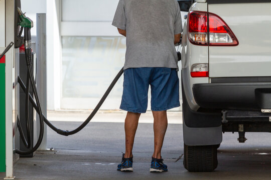 Man at fuel pump filling ute.