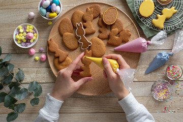 Process of decorating Easter cookies with colored icing - 497297635