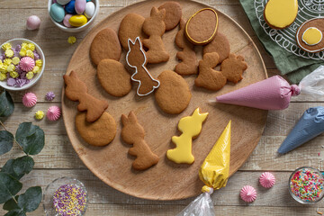 Decorating gingerbread cookies with colored icing for Easter