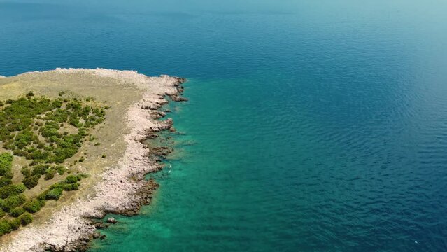 Aerial rotating view of two people swimming at Risika Beach on Krk island in Croatia