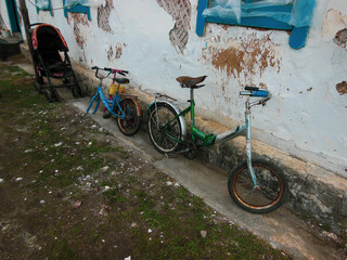 Pram and children's bicycles against the wall