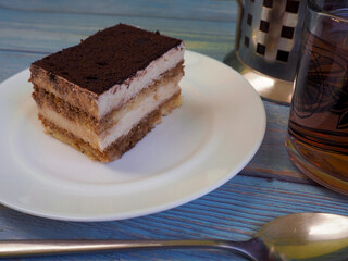 piece of chocolate cake. a piece of tiramisu cake with mascarpone cream is on a white plate