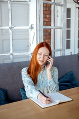 business young woman sitting at tables in a cafe and talking on the phone