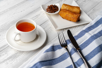 Russian pancakes with filling lying on a plate on table
